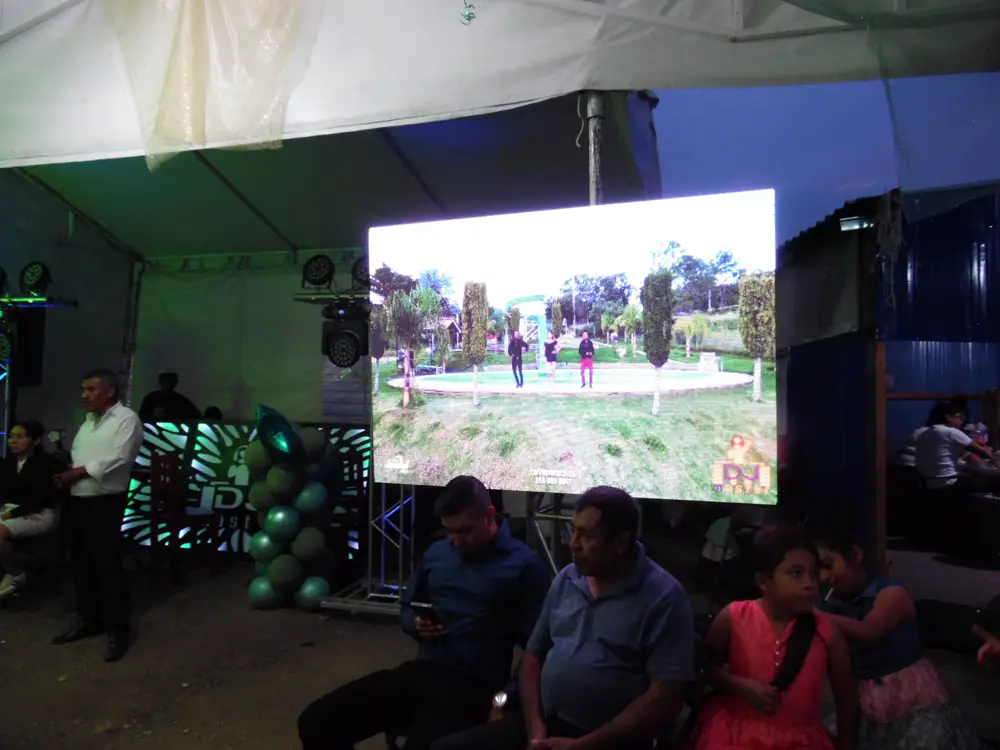 Pantalla LED pitch sobre truss mostrando video en un evento bajo carpa, junto a la cabina DJ Máster