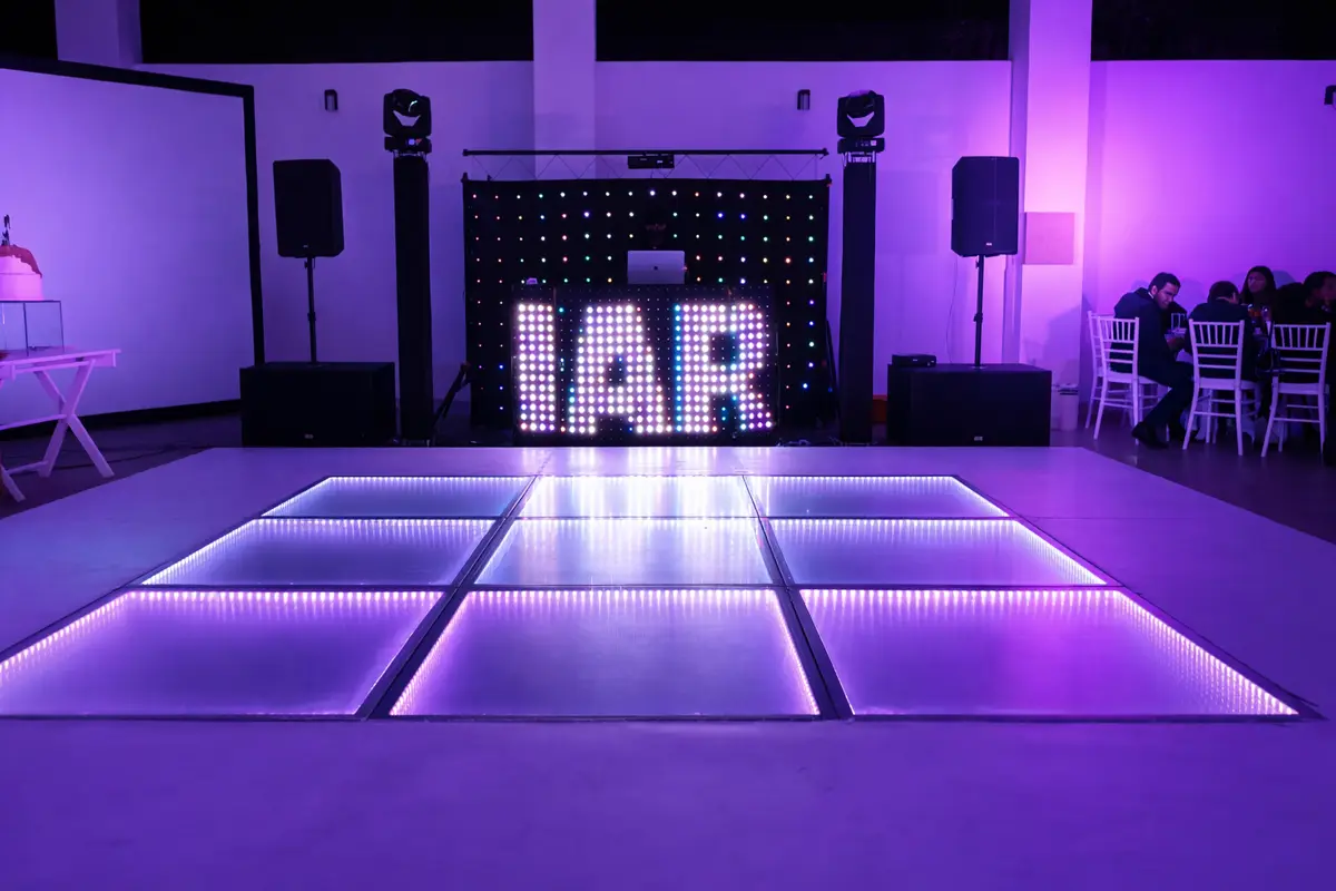 Pista de LEDs iluminada con letras gigantes al fondo en un salón de eventos